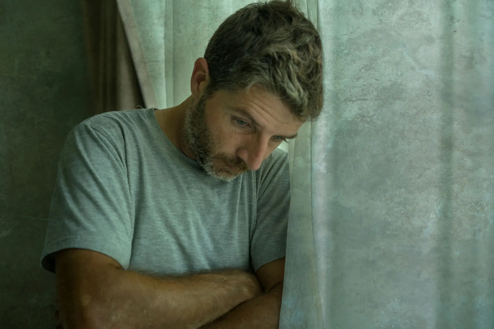 Individual leaning against a wall showing symptoms of fentanyl detox and withdrawal